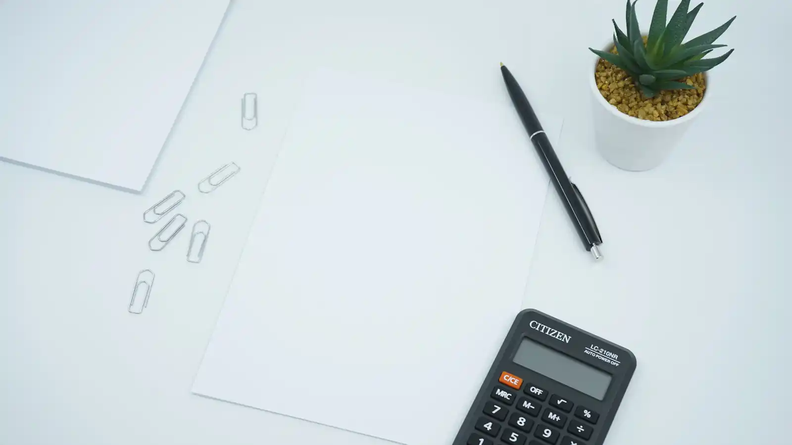 Calculator and pen on printed paper for cost calculations