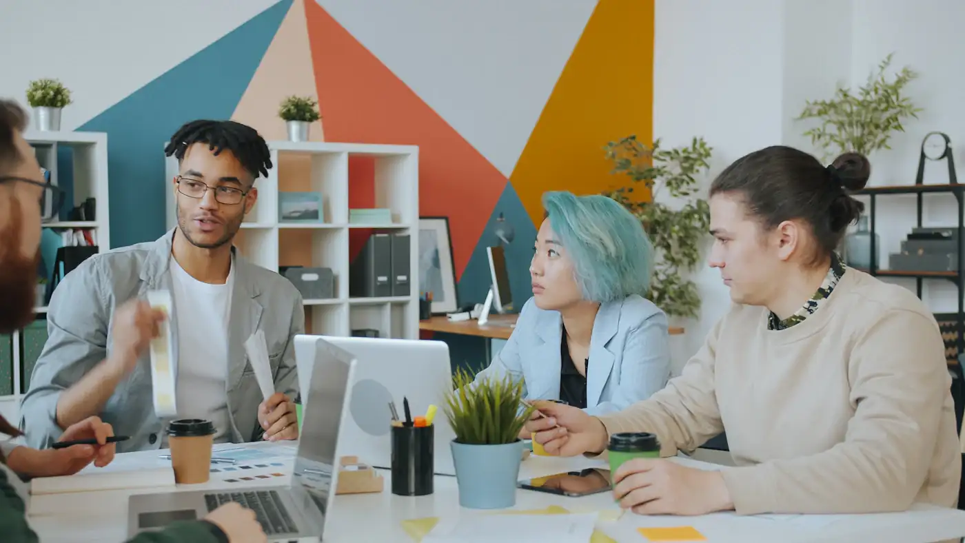 Diverse group of four people collaborating in a colourful workspace