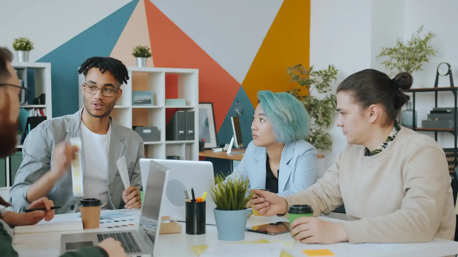 Diverse group of four people collaborating in a colourful workspace