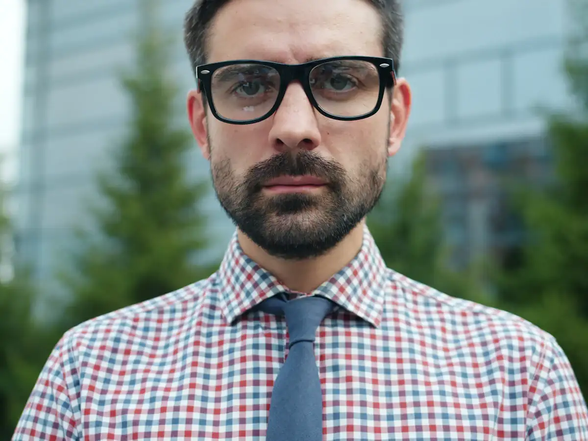 Executive candidate in glasses and tie looking forward