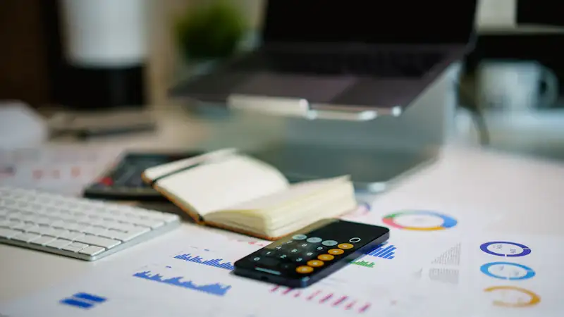 Office desk with a smartphone and financial charts