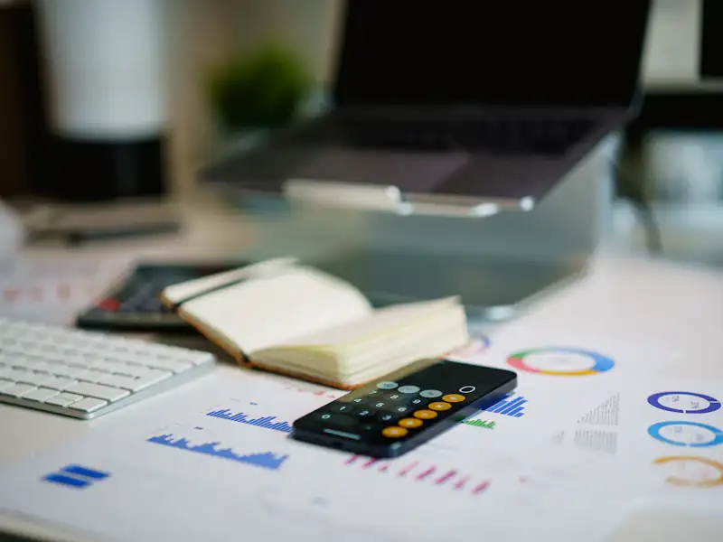 Office desk with a smartphone and financial charts