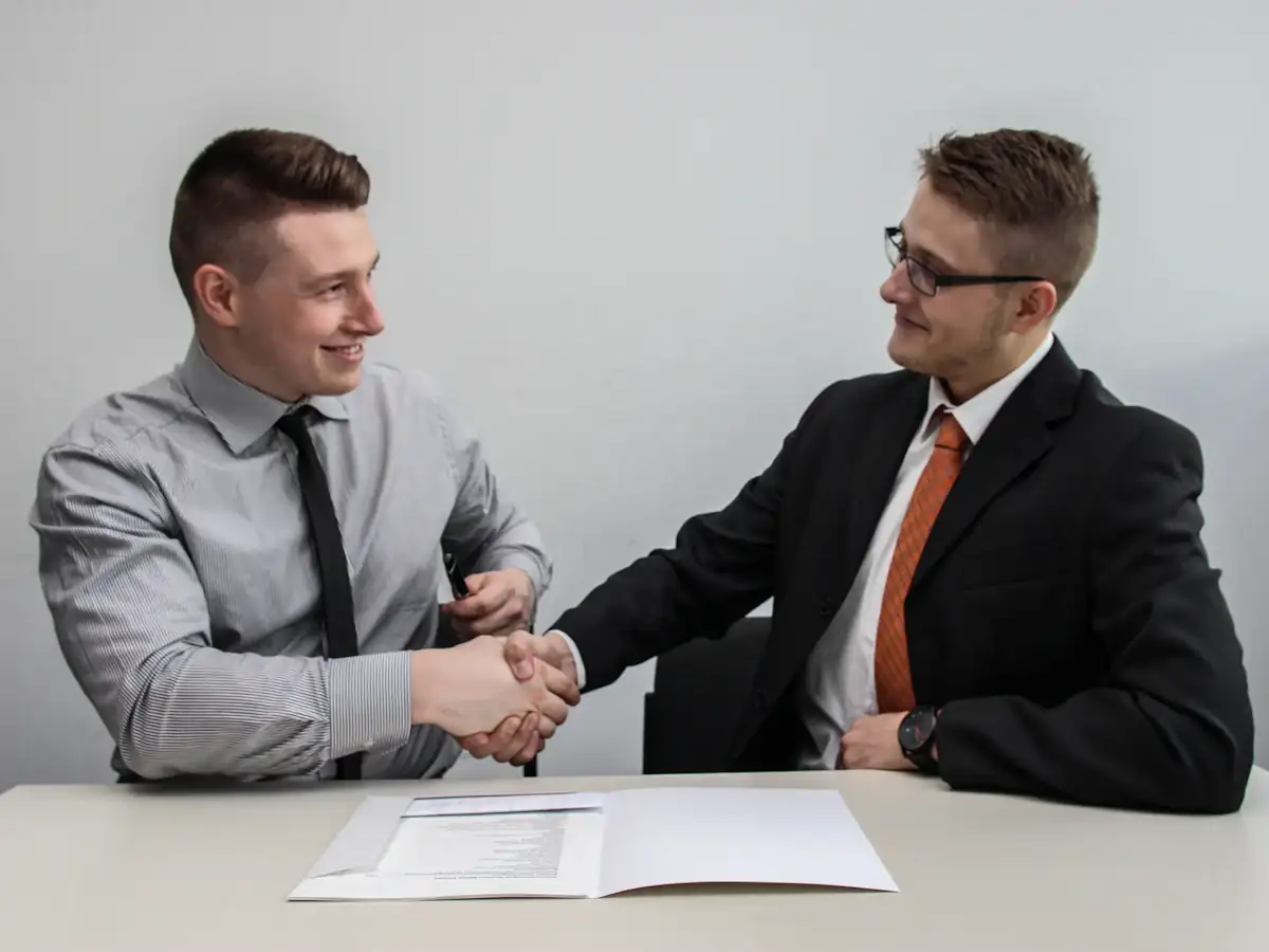Two businessmen shaking hands and smiling