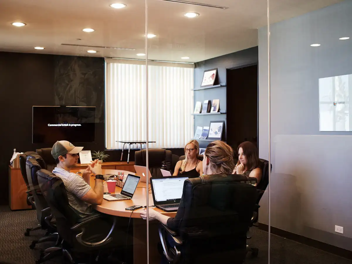 Team collaborating around a laptop in a meeting room
