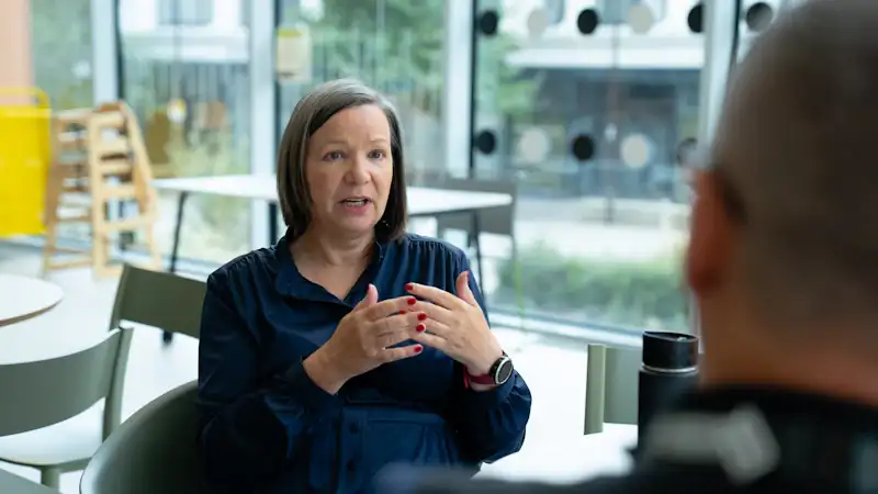Senior consultant coaching a colleague across a table