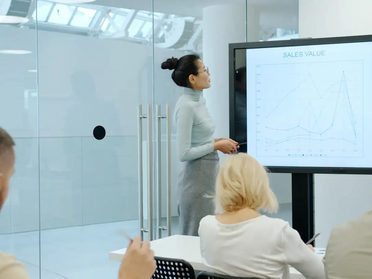 Woman presenting charts on a screen to colleagues