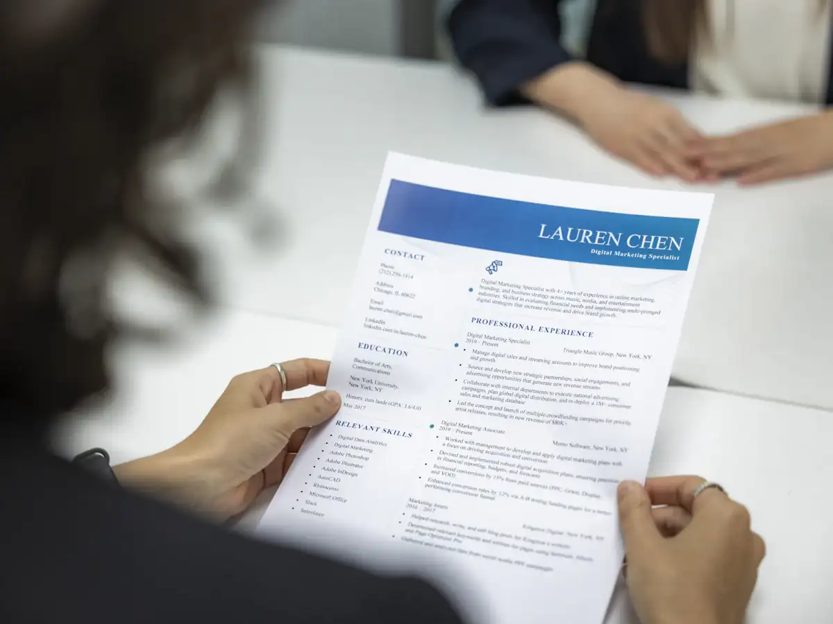 Recruiter reading a printed candidate resume at a table