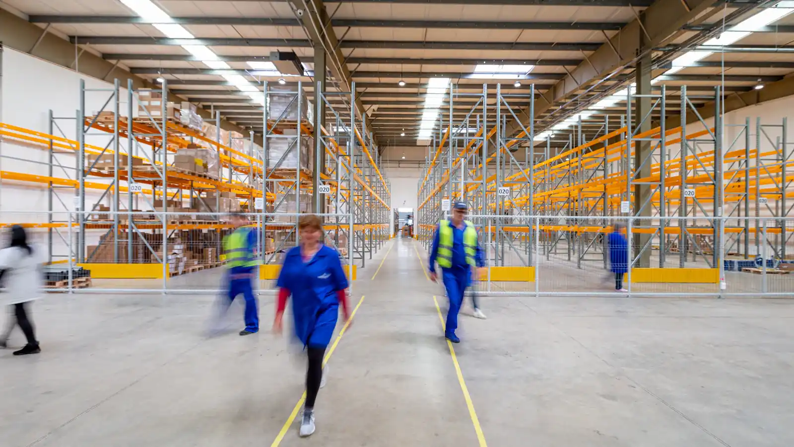Workers walking through a warehouse aisle